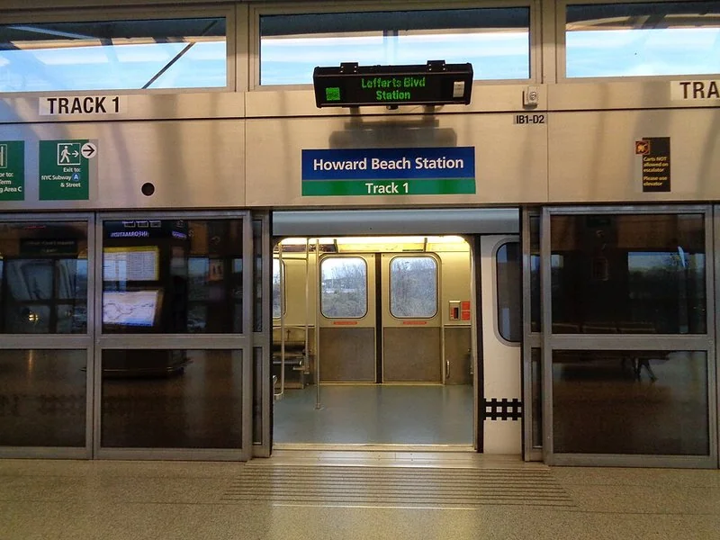 como ahorrar en jfk, Andén de la estación Howard Beach del AirTrain JFK, con el tren abierto y el indicador de Lefferts Boulevard.