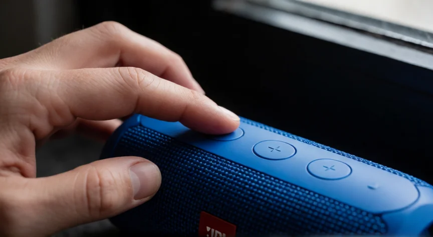 como aumentar jbl, Pulgar ajustando el botón de volumen de un JBL Flip 6