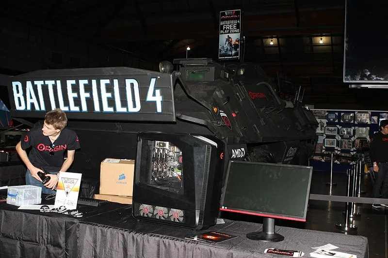 Estación de juego Battlefield con vehículo militar y pantalla en evento.