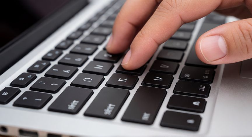 como cambiar el idioma del teclado, Manos tecleando en un portátil mostrando el teclado físico