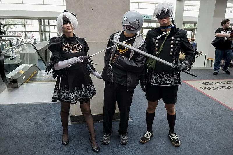 Cosplayers de 2B, Emil y 9S de NieR: Automata en una convención de videojuegos