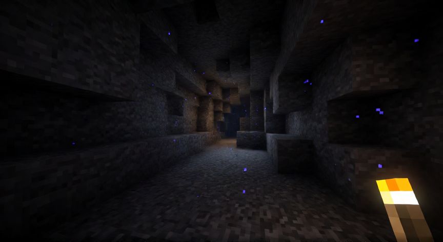 como encontrar warden en minecraft, Jugador con antorcha explorando una cueva profunda de Minecraft con partículas oscuras cerca del Warden