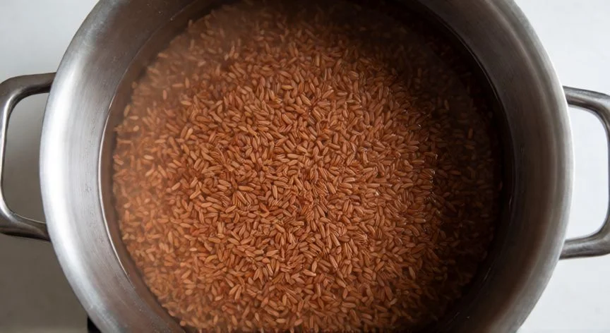 Arroz rojo en remojo en una olla grande antes de cocinar