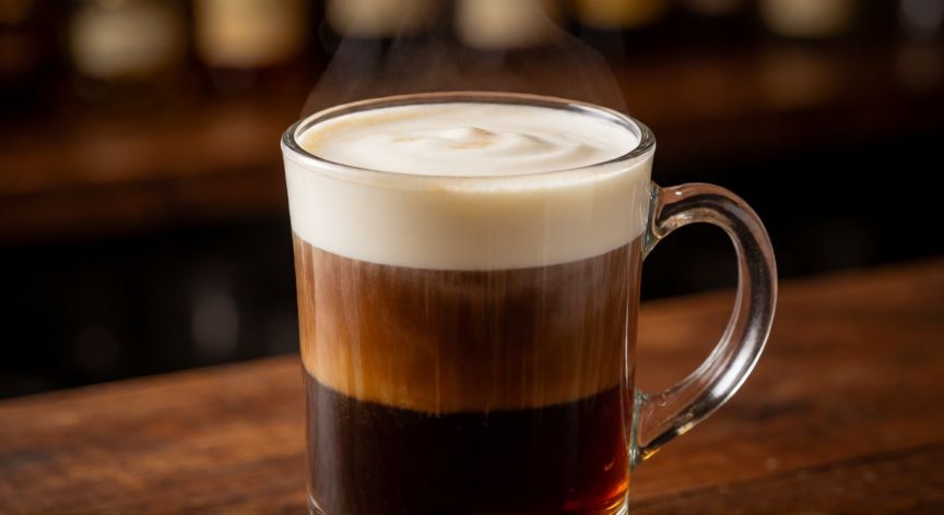 como hacer cafe irlandes tres colores, Vaso de café irlandés con capas visibles de café, whisky y crema