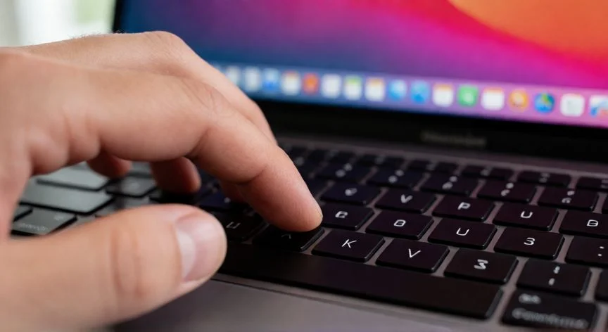 como hacer captura de pantalla en mac, Mano presionando teclas Command Shift y 3 en teclado de Mac