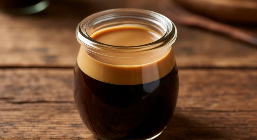 como hacer crema de cafe con agua y azucar, Crema de café casera en un bote de cristal sobre mesa de madera