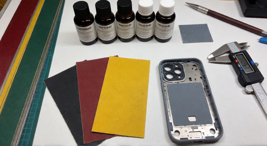 cómo hacer el nuevo iphone 18, Mesa de trabajo con herramientas y materiales para la fabricación artesanal de una maqueta de teléfono