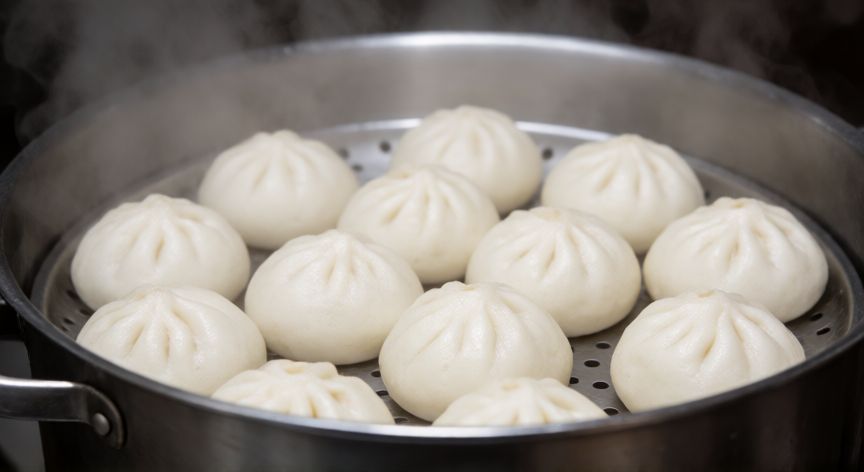 como hacer pan bao sin vaporera, Panes bao cocinándose en un colador dentro de una olla con vapor