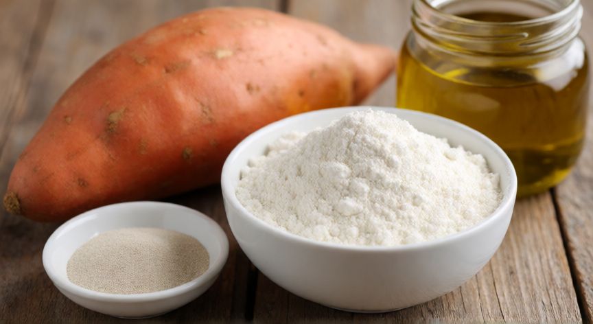 cómo hacer un pan de batata, Ingredientes frescos para preparar pan de batata sobre mesa de madera