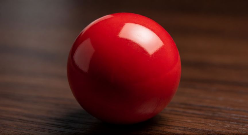 Esfera roja brillante con sombreado realista sobre mesa de madera