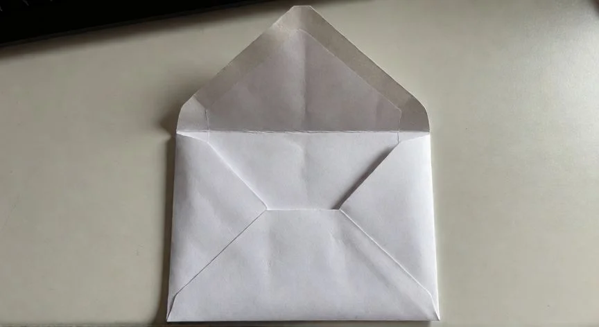 como hacer un sobre con un folio, Vista superior de un sobre casero terminado con la solapa abierta mostrando los pliegues internos
