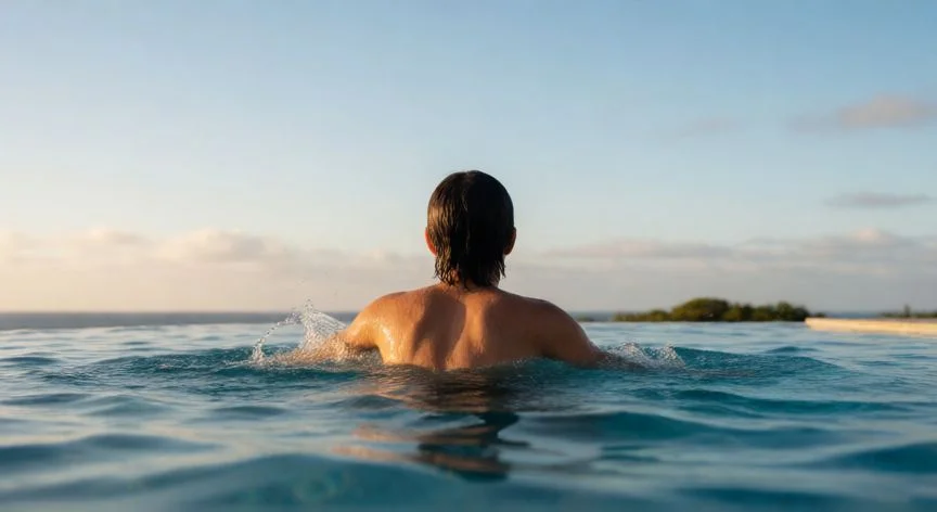 como mejorar mis pulmones, Persona nadando en una piscina exterior al atardecer