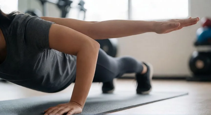 como mejorar mis push ups, Ejercicio de push up arquero en un gimnasio con iluminación natural
