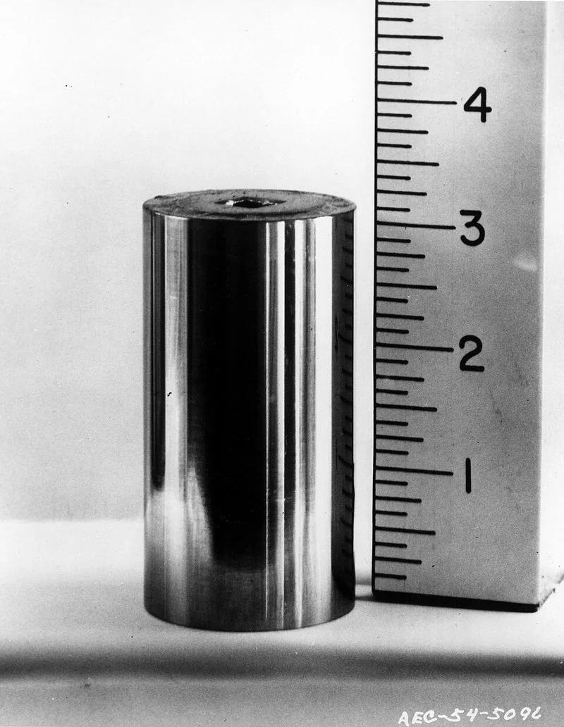 como se fabrica el cesio 137, Cápsula metálica cilíndrica sellada de una fuente de cesio-137 junto a una regla de referencia