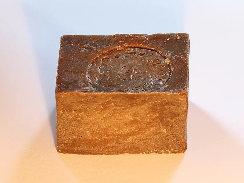 Pastilla de jabón de Alepo con sello estampado, corteza oscura y interior ocre
