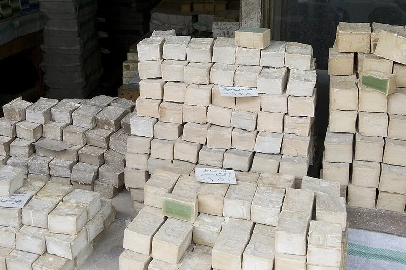 como se fabrica el jabon de alepo, Pilas de pastillas de jabón de Alepo apiladas para su secado en un comercio