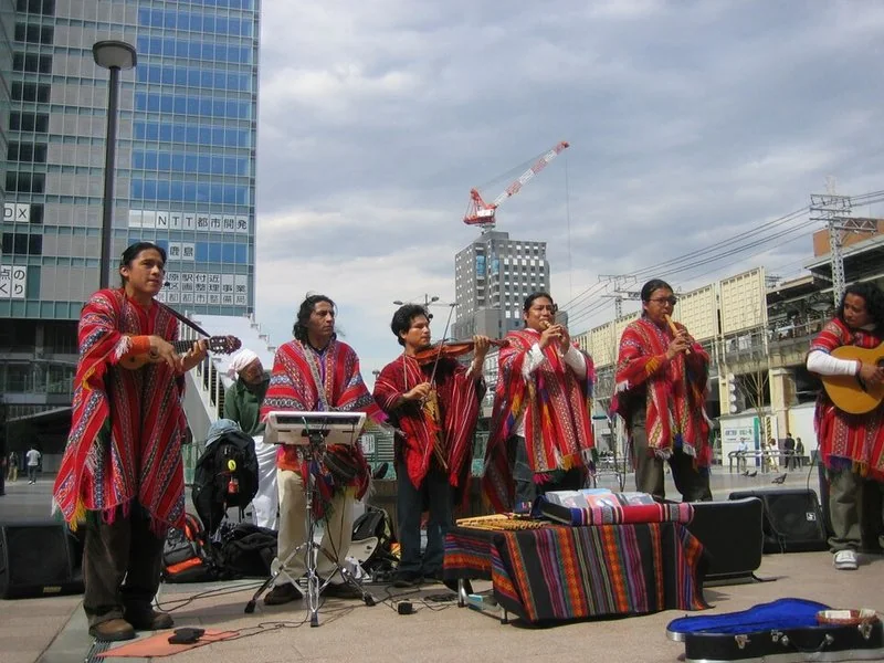 como se fabrica la quena, Músicos andinos con ponchos tocando quenas en la calle