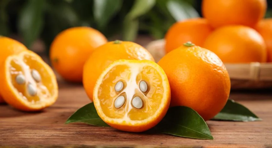 Fruta de níspero madura con huesos visibles sobre mesa de madera