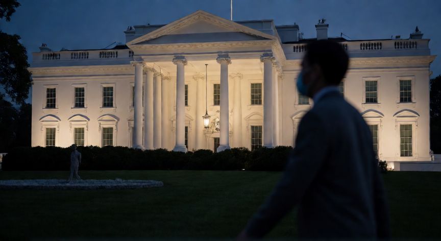covid 19 casa blanca, Fachada de la Casa Blanca por la noche con una figura enmascarada