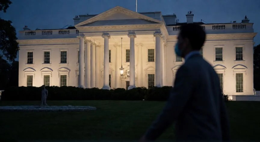 Fachada de la Casa Blanca por la noche con una figura enmascarada