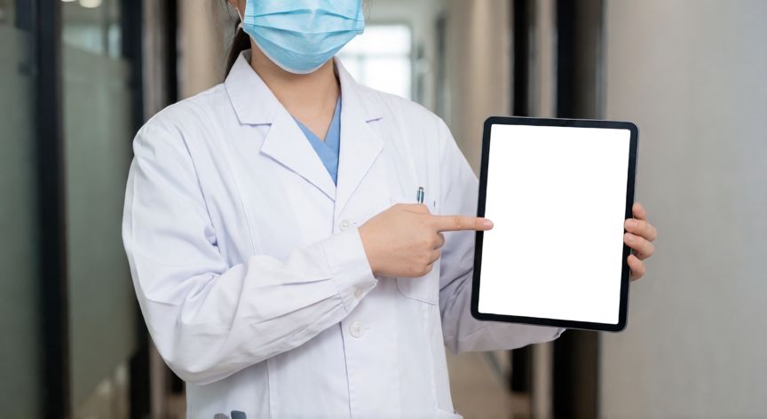 covid 19 guia de practica clínica, Médico revisando protocolo clínico en una tableta digital dentro de una clínica moderna