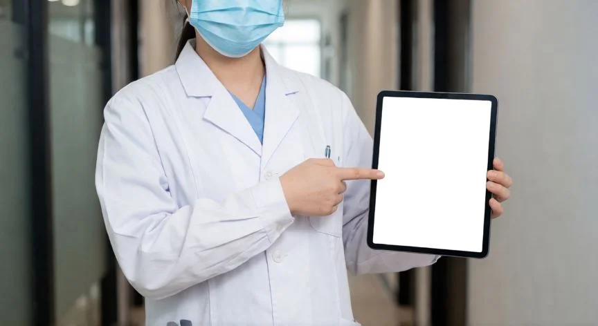 Médico revisando protocolo clínico en una tableta digital dentro de una clínica moderna