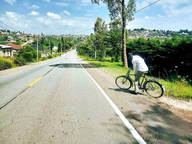 Carretera casi vacía en Uganda durante el confinamiento por la COVID-19, con un ciclista a un lado de la calzada