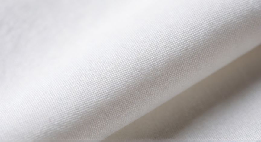 Detalle macro de la textura de un tejido blanco mostrando la estructura de hilos