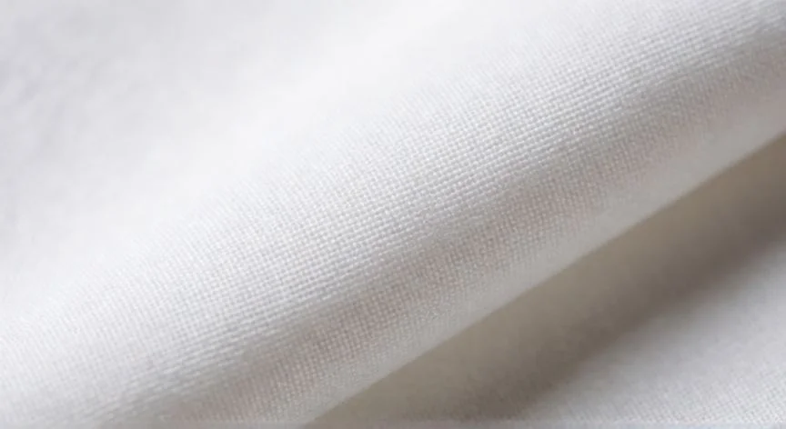 Detalle macro de la textura de un tejido blanco mostrando la estructura de hilos