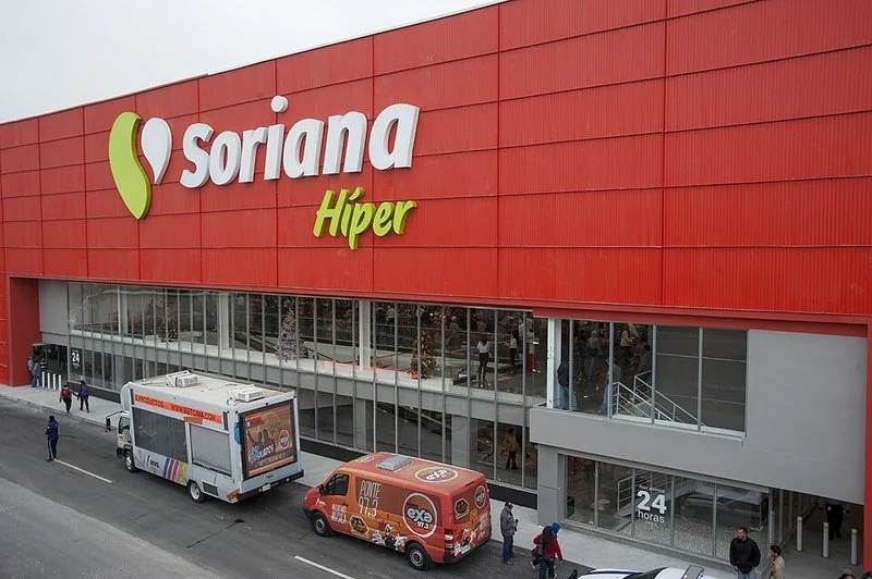 Fachada roja de un hipermercado Soriana Híper con entrada de 24 horas