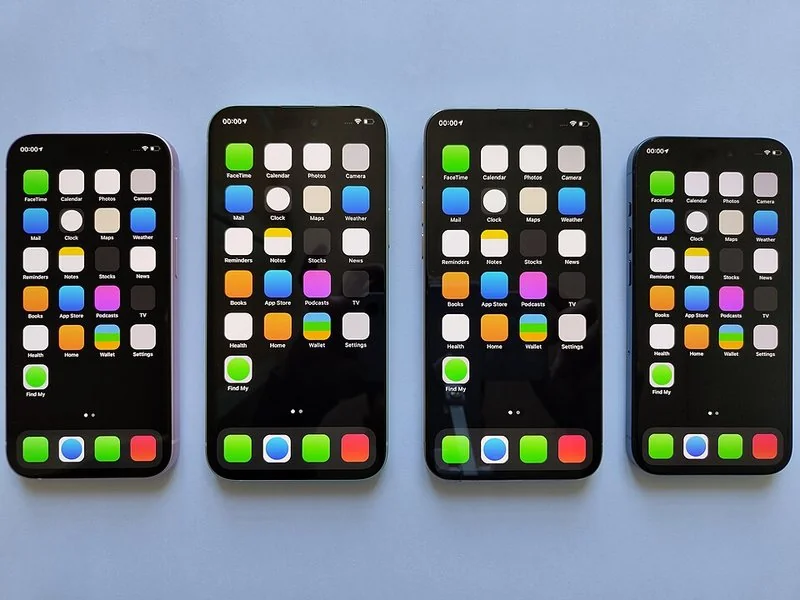 Cuatro iPhone mostrando la pantalla de inicio con las apps nativas de iOS