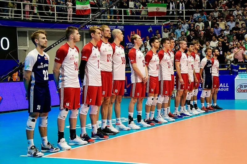 La selección de voleibol de Polonia, de blanco y rojo, formada en la cancha antes de un partido ante Irán