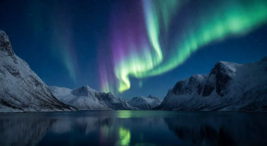 Auroras boreales sobre un fiordo nevado en Noruega