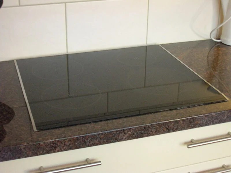 mejor producto para limpiar la vitrocerámica, Placa de inducción de cristal negro limpia e integrada en una encimera de cocina