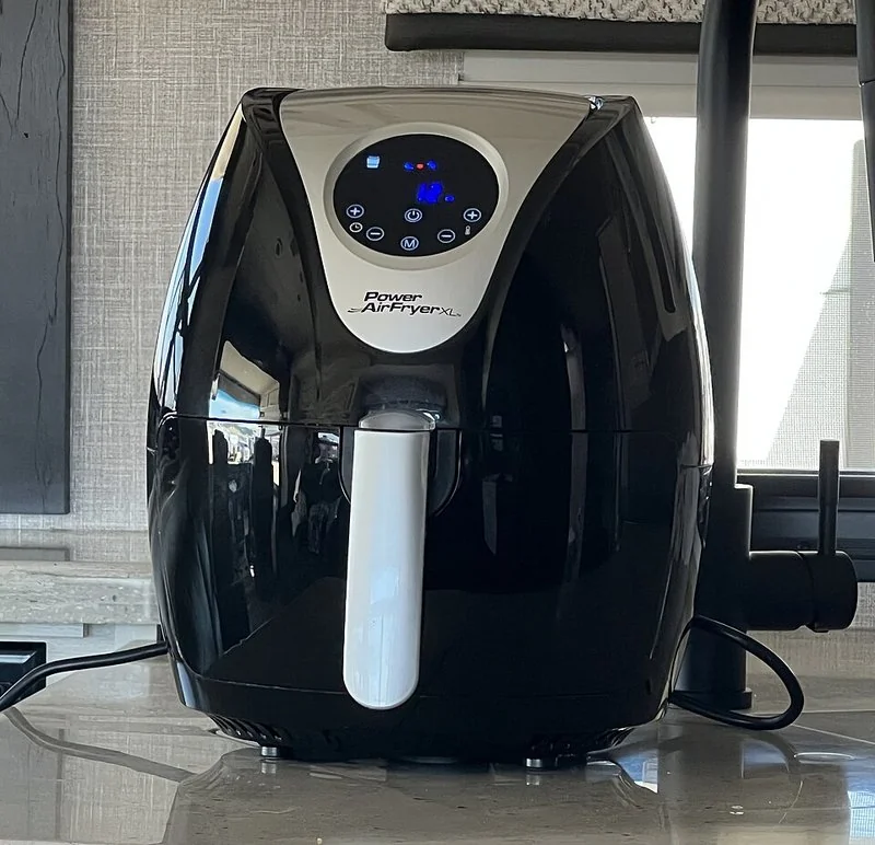 mejor producto para vender, Freidora de aire Power Air Fryer XL negra con panel digital y asa blanca sobre mesa