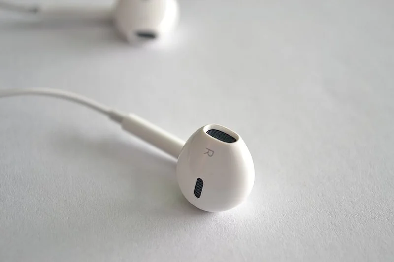 Auriculares blancos de Apple sobre fondo claro, accesorio tecnológico de alta rotación en Amazon