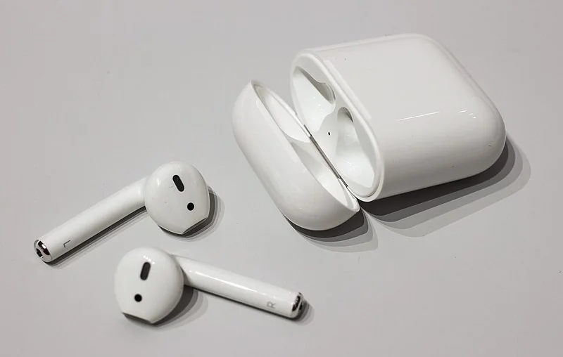 Auriculares inalámbricos blancos con su estuche de carga abierto