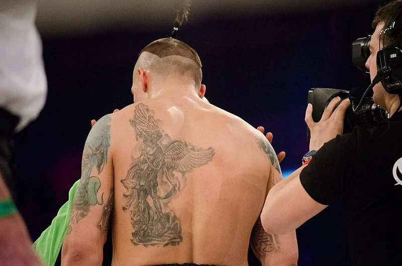 Oleksandr Usyk, campeón absoluto ucraniano, de espaldas con su tatuaje en el ring