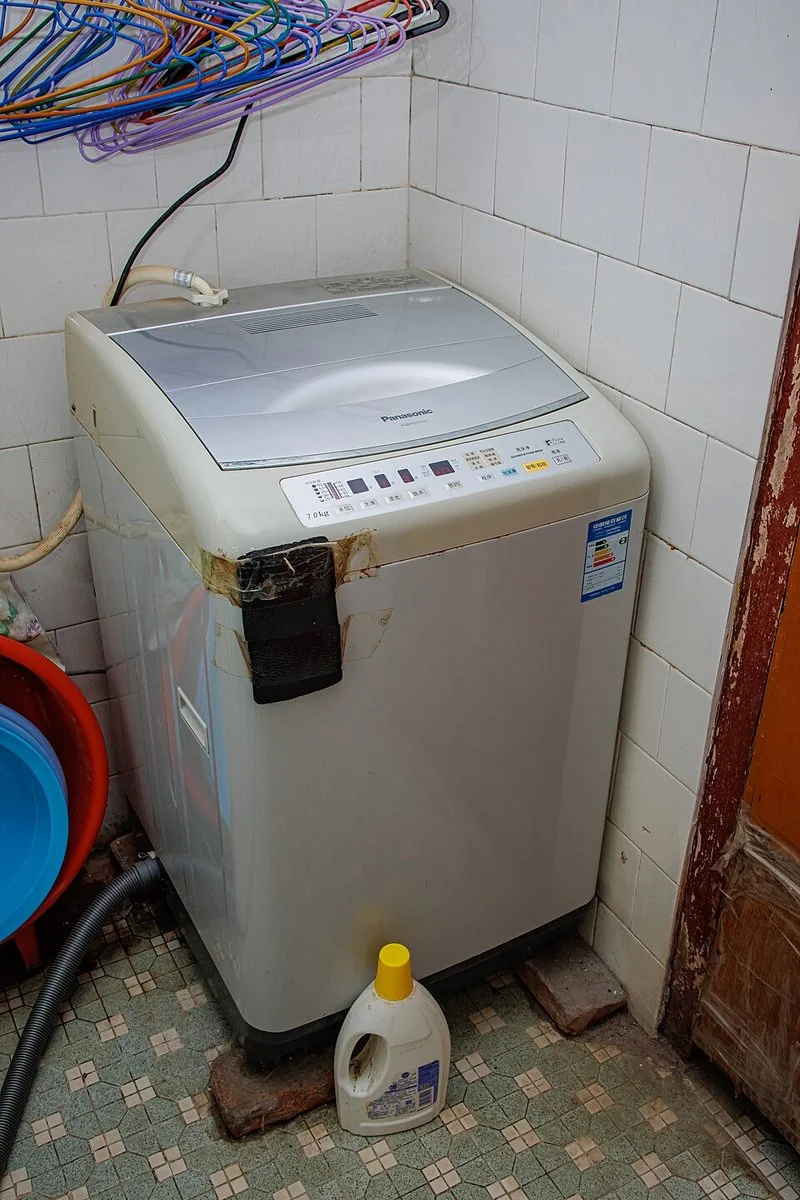 Lavadora automática de carga superior con mangueras de entrada y desagüe