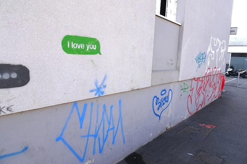 que es imessage iphone, Grafiti en pared con burbuja verde 'I love you' y indicador de escritura gris