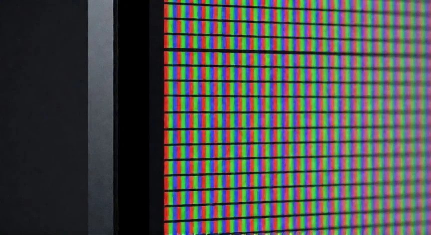 Monitor moderno mostrando colores con subpíxeles RGB visibles en primer plano