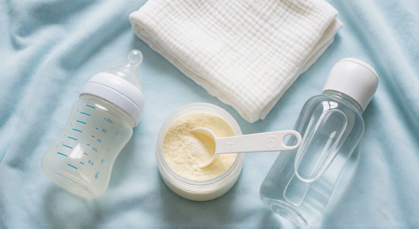 que formula comprar para recien nacido, Preparación de biberón con fórmula infantil en vista cenital sobre mantita