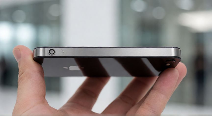 que iphone habia en 2010, Mano sosteniendo un iPhone 4 mostrando su marco de acero