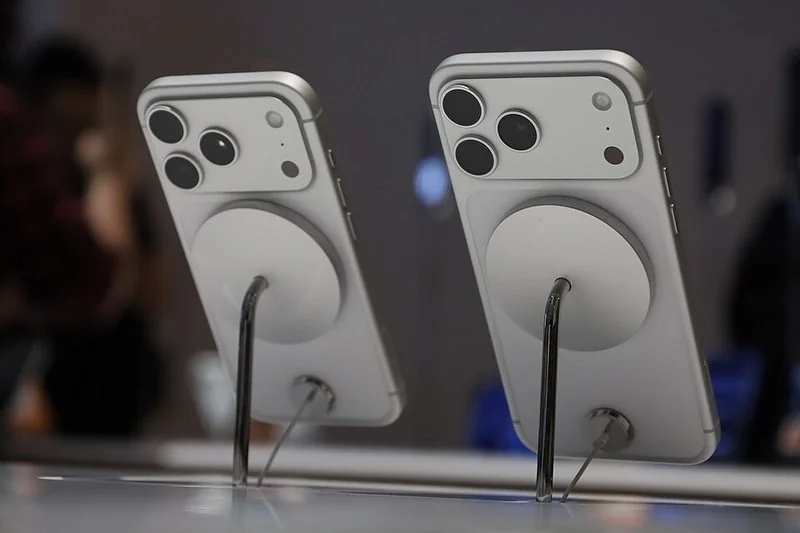 que iphone lleva chip, Traseras de dos iPhone 17 Pro plateados con MagSafe y cámara triple expuestos en tienda