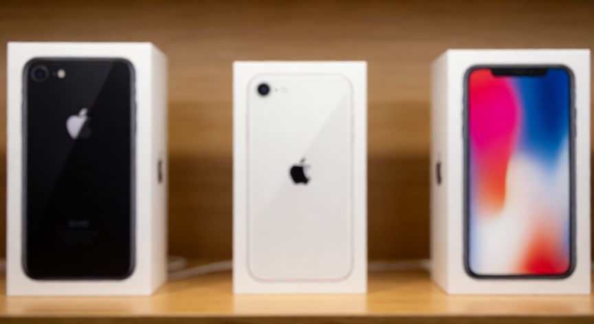 que iphone queda descontinuado, Estante de tienda con cajas de modelos antiguos de iPhone descontinuados