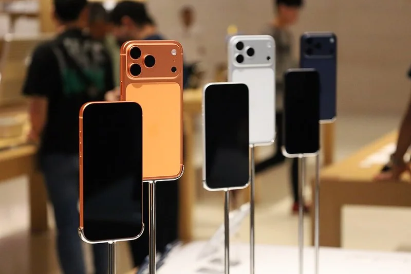 iPhone 17 Pro en naranja cósmico, blanco y azul expuestos en tienda