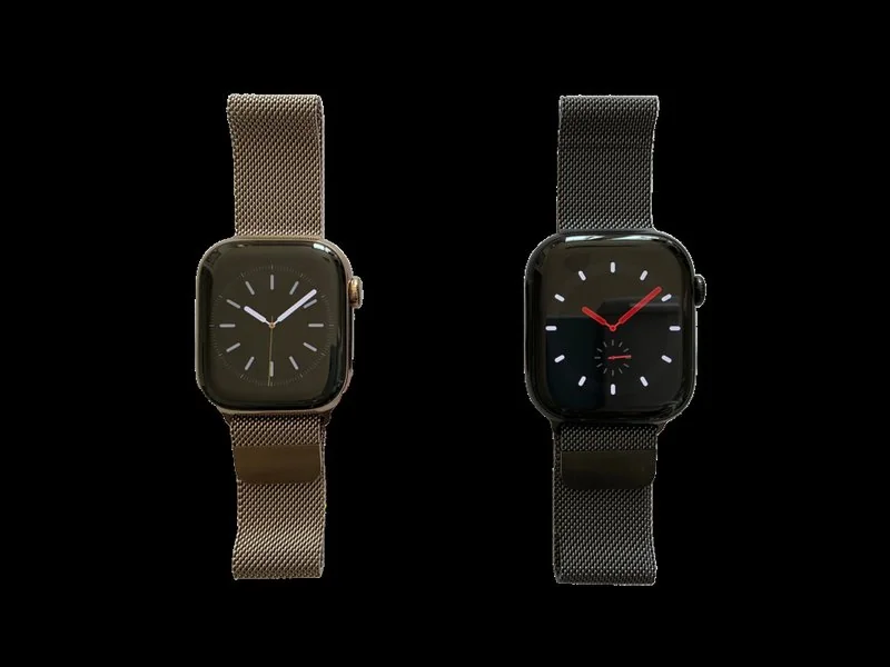 Dos Apple Watch con correa malla milanesa, uno en oro y otro negro, sobre fondo oscuro