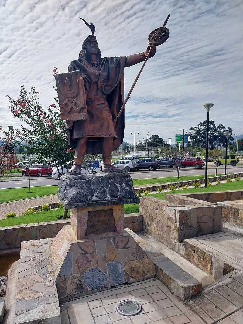 Escultura de Manco Cápac (Ayar Manco), hermano mayor de Ayar Uchu y Ayar Auca y fundador del linaje inca, con escudo, vara y penacho, sobre un pedestal de piedr