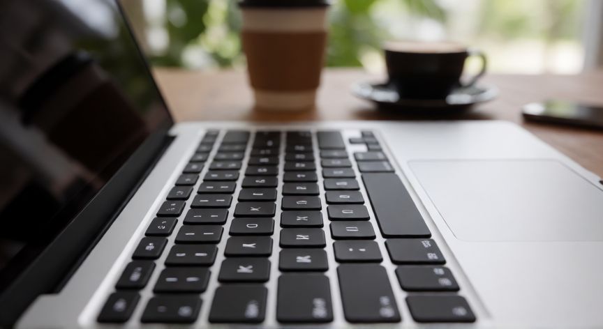 que ordenador comprar portatil, Teclado retroiluminado de un portátil moderno en un escritorio de trabajo
