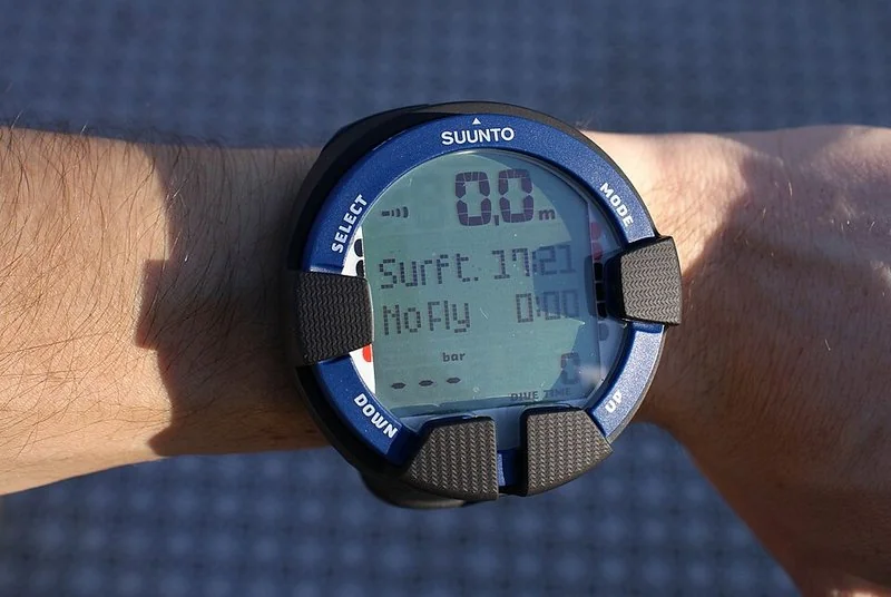 que ordenador de buceo comprar, Ordenador de buceo Suunto en la muñeca mostrando profundidad, tiempo en superficie y No Fly